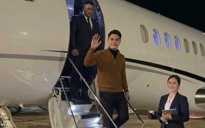 Pengusaha muda tampil percaya diri saat menuruni tangga jet pribadi di bandara pada malam hari.